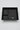 A black plastic organizer tray with three compartments, photographed from above on a light beige marble-patterned surface.